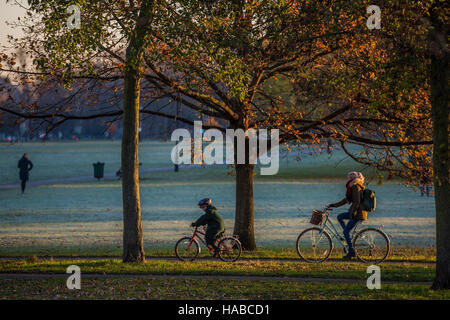 Clapham Common, London, UK. 29th November, 2016. Families on their way to school and commuters on bikes cross the common. It is a cold and frosty morning on Clapham Common. London 29 Nov 2016. Credit:  Guy Bell/Alamy Live News Stock Photo