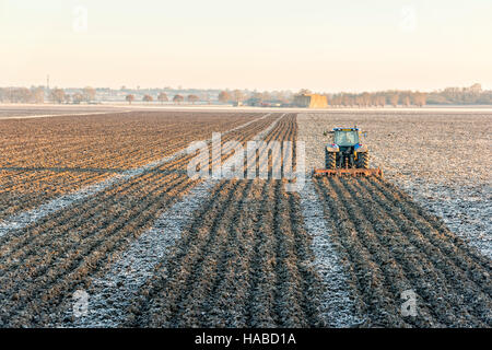 Aldreth, Cambridgeshire UK 29th November 2016. A farmer cultivates frozen fields in the flat landscape of the Cambridgeshire Fens where temperatures fell overnight to minus 4 degrees centigrade on one of the coldest nights of the winter so far this year. Further freezing conditions are forecast for the next few days. Credit Julian Eales/Alamy Live News Stock Photo