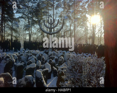 Rumbala, Latvia. 29th Nov, 2016. Visitors lay flowers by a large menorah monument at an memoral for the victims of the Shoah 75 years ago in Rumbala, Latvia, 29 November 2016. The President of Latvia, Vejonis, spoke of the 'immense crimes' carried out during the German occupation of the country in the Second World War at the event in front of the city gates of the capital, Riga. More than 25,000 Jews were murdered by the National Socialists in Rumbula between 30 November and 08 December in 1941. Photo: Alexander Welscher/dpa/Alamy Live News Stock Photo