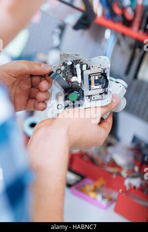 Close up of mans hands holding drone camera with chips Stock Photo