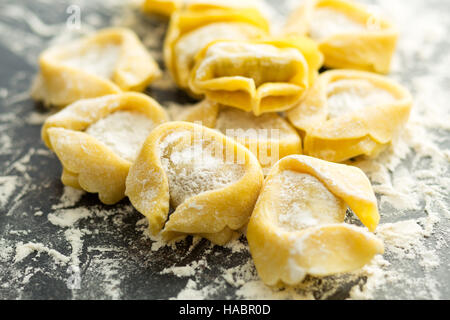 Italian traditional tortellini pasta and white flour. Stock Photo