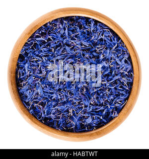 Dried cornflowers in wooden bowl. Edible flowers of Centaurea cyanus with intense blue pigment, used for tea and salads. Stock Photo