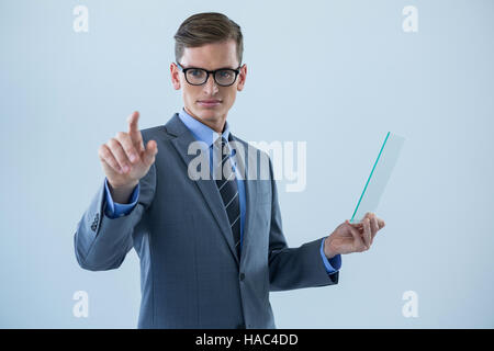 Businessman holding a glass sheet and touching an invisible screen Stock Photo