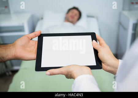 Doctors using digital tablet in ward Stock Photo