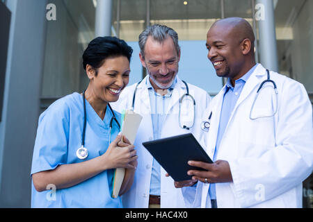 Surgeons and nurse having discussion on digital tablet Stock Photo