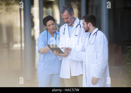 Surgeons and nurse having discussion on digital tablet Stock Photo