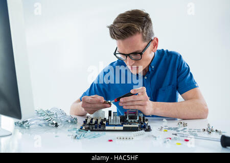 Computer technician repairing motherboard Stock Photo