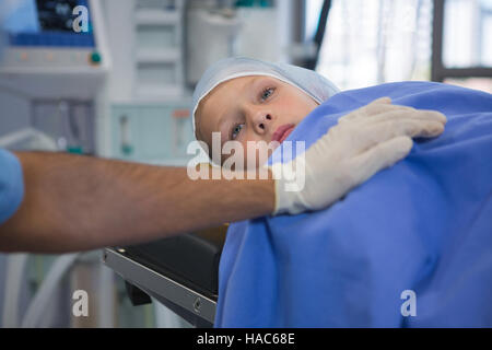 Male surgeon consoling patient in operation theater Stock Photo