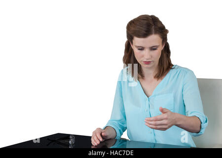 Businesswoman sitting at desk and using digital screen Stock Photo