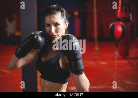 Confident female boxer performing boxing stance Stock Photo