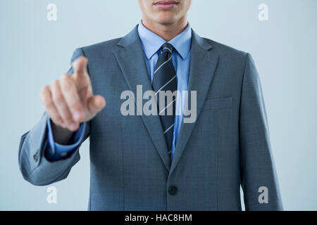 Mid section of businessman touching an invisible screen Stock Photo