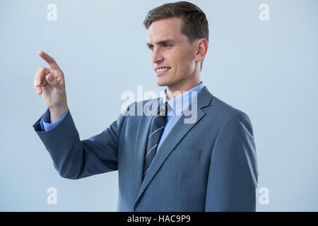 Smiling businessman touching an invisible screen Stock Photo