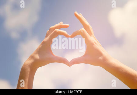 Symbol of love, human hands in heart shape towards blue sky Stock Photo ...