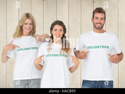 Three volunteer pointing at message printed on their tshirt Stock Photo