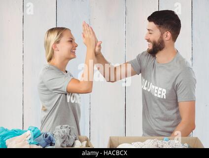 Volunteer couple giving high five to each other Stock Photo