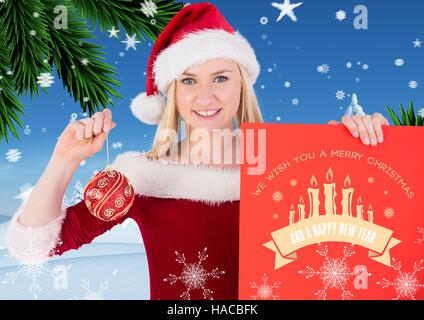 Beautiful woman in santa costume holding merry christmas card and bauble Stock Photo