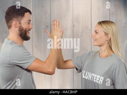 Volunteer couple in tshirt giving high five to each other Stock Photo