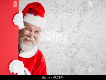 Santa claus peeking behind wall Stock Photo