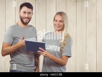 Volunteer couple using digital tablet and showing thumbs up Stock Photo