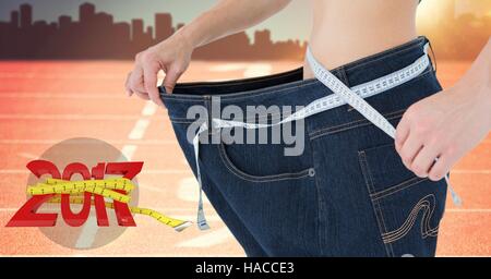 Mid section of woman measuring her waist against 3D 2017 Stock Photo