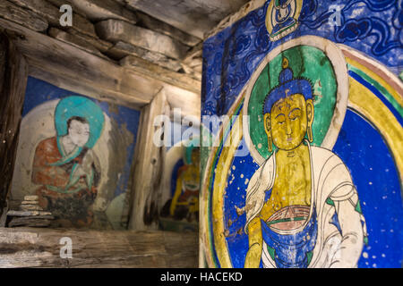 Old buddhists paintings on mani wall in Nepalese village. Stock Photo