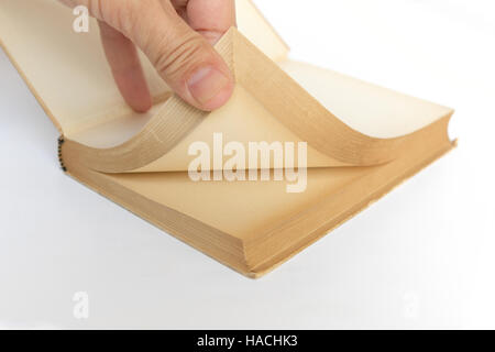 hand turning pages of old book with blank yellowed pages Stock Photo