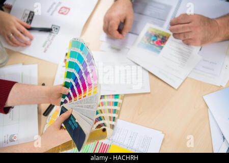 Graphic designers choosing from a Pantone colour fan deck Stock Photo