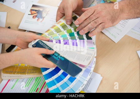 Graphic designers choosing from a Pantone colour fan deck Stock Photo