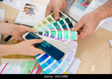 Graphic designers choosing from a Pantone colour fan deck Stock Photo