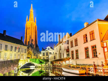 Bruges, Belgium. Church of Our Lady, Vrouwekerk. Night shot of historic medieval buildings along a canal in Brugge, Flanders. Stock Photo