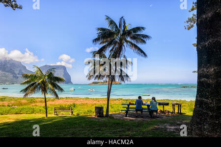 Couple sat in front of The Lagoon, Lord Howe Island, New South Wales, NSW, Australia Stock Photo