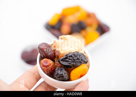 Muslim hand presenting collection of Ramadan dried fruits Stock Photo