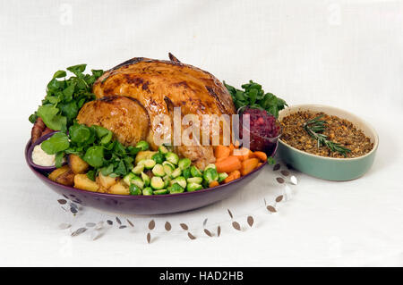 A roasted Christmas turkey complete with Brussels Sprouts, roast potatoes, carrots and stuffing in a large round dish.a UK Stock Photo