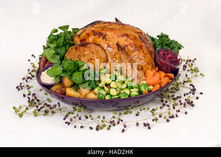 A roasted Christmas turkey complete with Brussels Sprouts, roast potatoes, carrots and stuffing in a large round dish.a UK Stock Photo