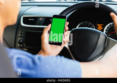 man using maps app on phone in car, phone green screen easy for adjustment Stock Photo
