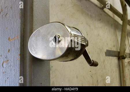 Vintage metal pencil sharpener mounted on wall. Stock Photo