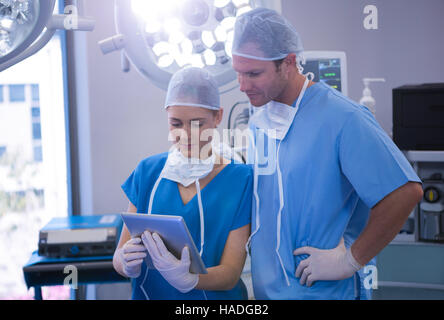 Male and female nurse using digital tablet in operation theater Stock Photo