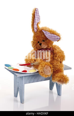 Easter bunny soft toy with colour palette made of easter eggs and painting brush Stock Photo