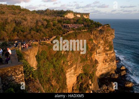 Tourists along the cliffs next to the Ulu Watu temple Pura Luhur. Bali. Uluwatu Temple is a Hindu temple set on the cliff bank in south part of Bali P Stock Photo