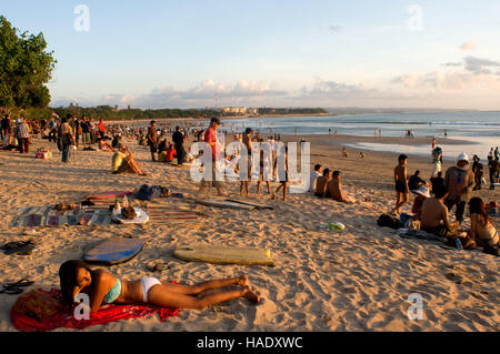 At dusk everyone gathers to watch the sunset with a beer on the beach of Kuta. Surfers on the beach of Kuta. Surfing lessons. Bali. Kuta is a coastal Stock Photo