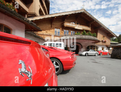 Red Ferrari cars parked infront of the five-star Stanglwirt Organic Spar Hotel in Going, Tyrol, Austria, Europe Stock Photo