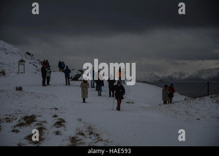 Tourists look out over the town of Hammerfest in northern Norway under wintery conditions. Stock Photo