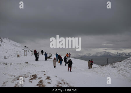 Tourists look out over the town of Hammerfest in northern Norway under wintery conditions. Stock Photo