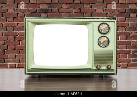 Grungy green vintage television set with brick wall and cut out screen. Stock Photo