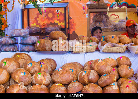 Women selling traditional Mexican Bread called Bread of the Dead in Oaxaca market. this bread eaten during Day of the Dead festivities in Mexico. Stock Photo