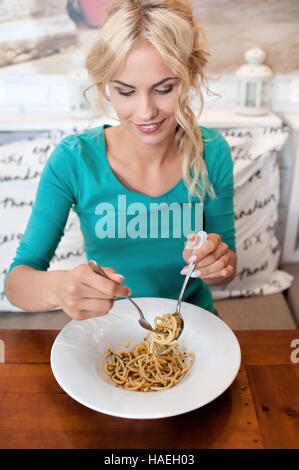Young woman eats alone in restaurant Stock Photo