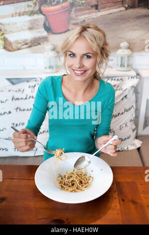 Young woman eats alone in restaurant Stock Photo