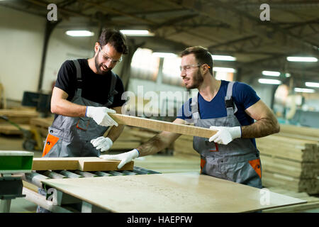 Young workers work in a factory for the production of furniture Stock Photo