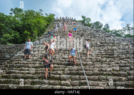 COBA, MEXICO - November, 13, 2013: Group of tourists climbing Nohoch Mul pyramid in Coba, Mexico Stock Photo