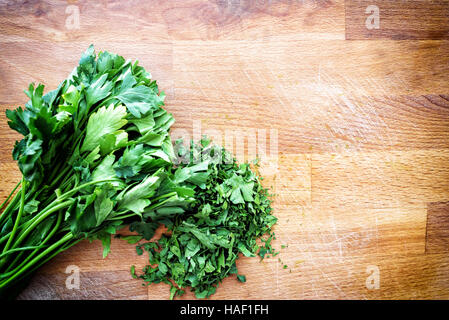 https://l450v.alamy.com/450v/haf1fh/chopped-parsley-on-a-rustic-wooden-chopping-board-in-a-overhead-direct-haf1fh.jpg